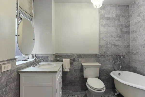 a bathroom with a toilet a sink and mirror