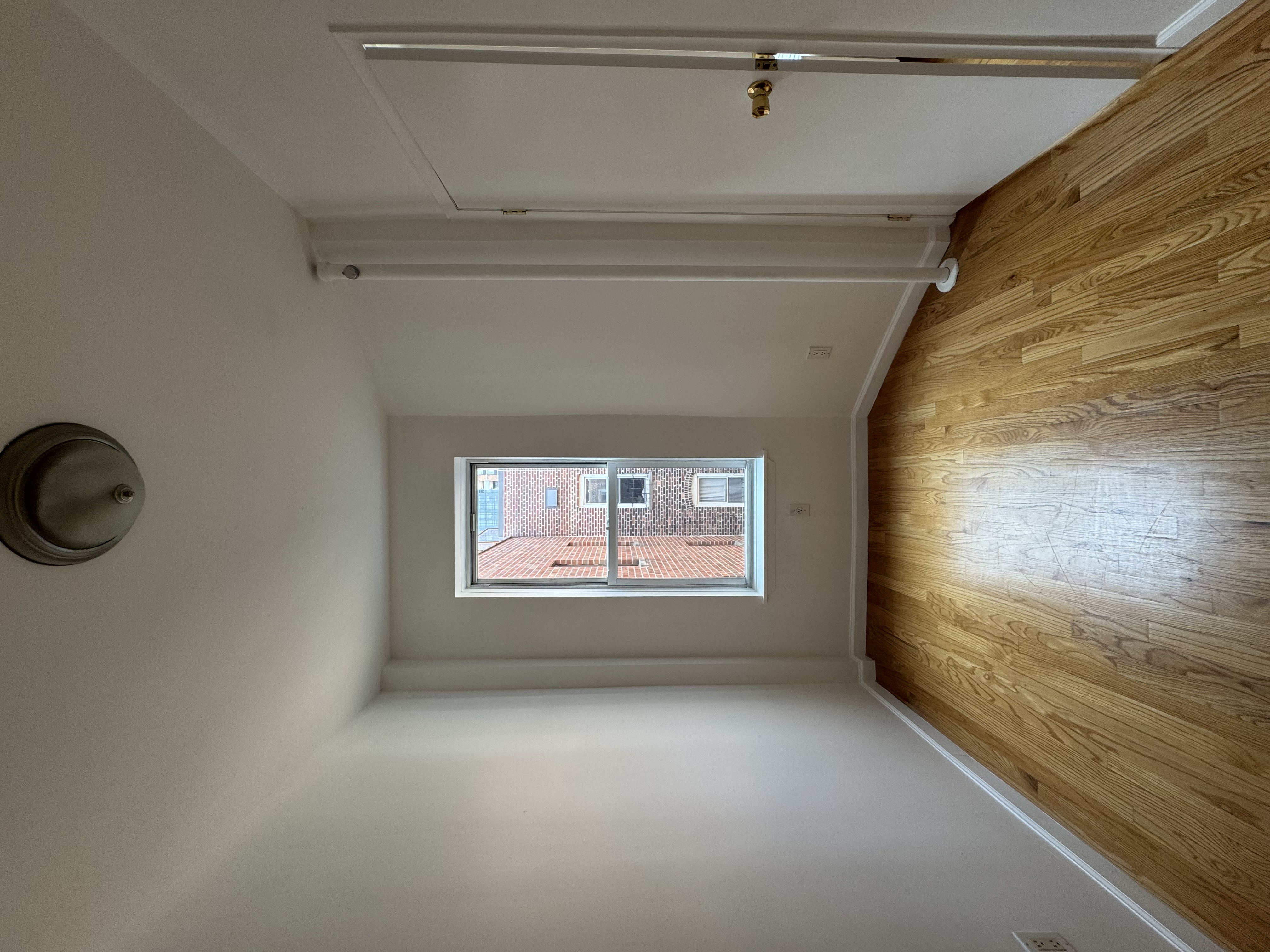 451 West 44th Street, Unit 63 Manhattan, NY 10036 - Photo 2 of 31 an empty room with wooden floor and windows