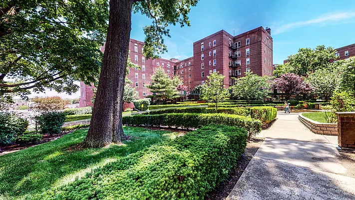 5635 Netherland Avenue, Unit 1G Bronx, NY 10471 - Photo 7 of 7 a view of a large building with a big yard and large trees