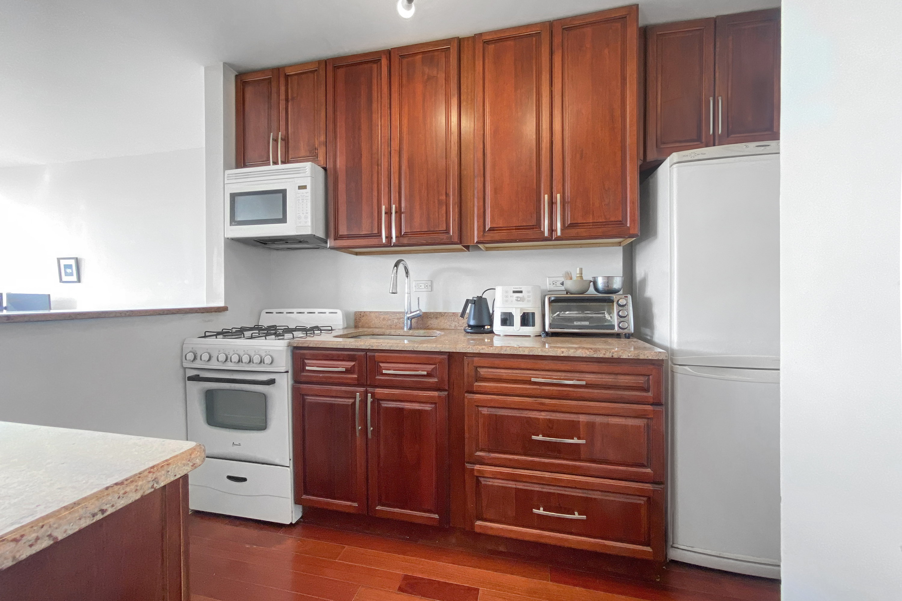 333 East 30th Street, Unit 20E Manhattan, NY 10016 - Photo 4 of 14 a kitchen with a cabinets and white appliances