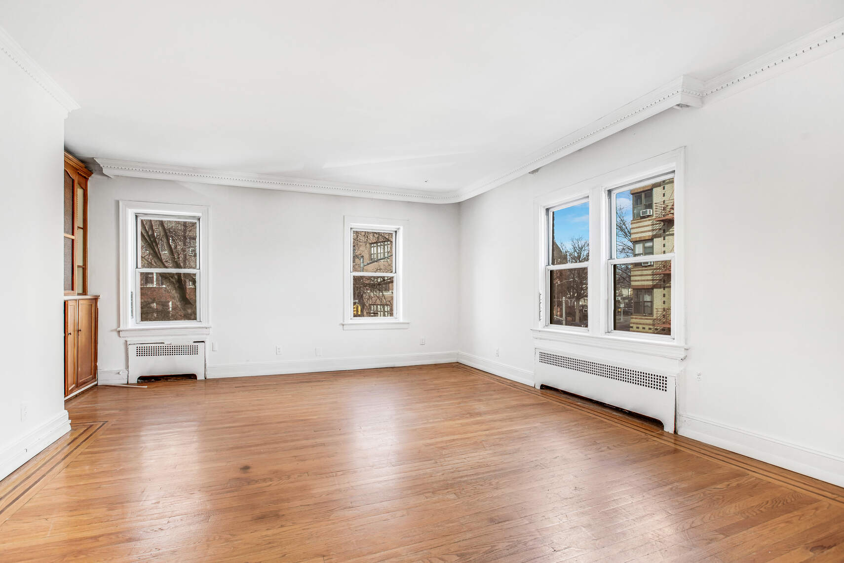 8301 4th Avenue Brooklyn, NY 11209 - Photo 2 of 20 an empty room with wooden floor and windows