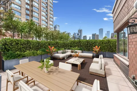a view of a patio with couches table and chairs and potted plants