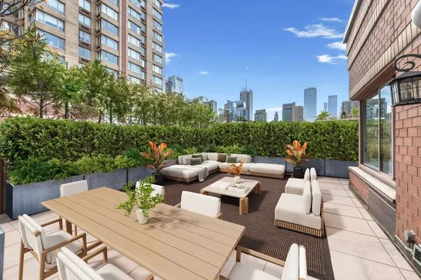 a view of a patio with couches table and chairs and potted plants