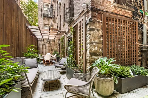 a view of a patio with plants and chairs