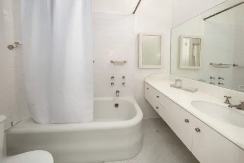 a bathroom with a tub sink and mirror