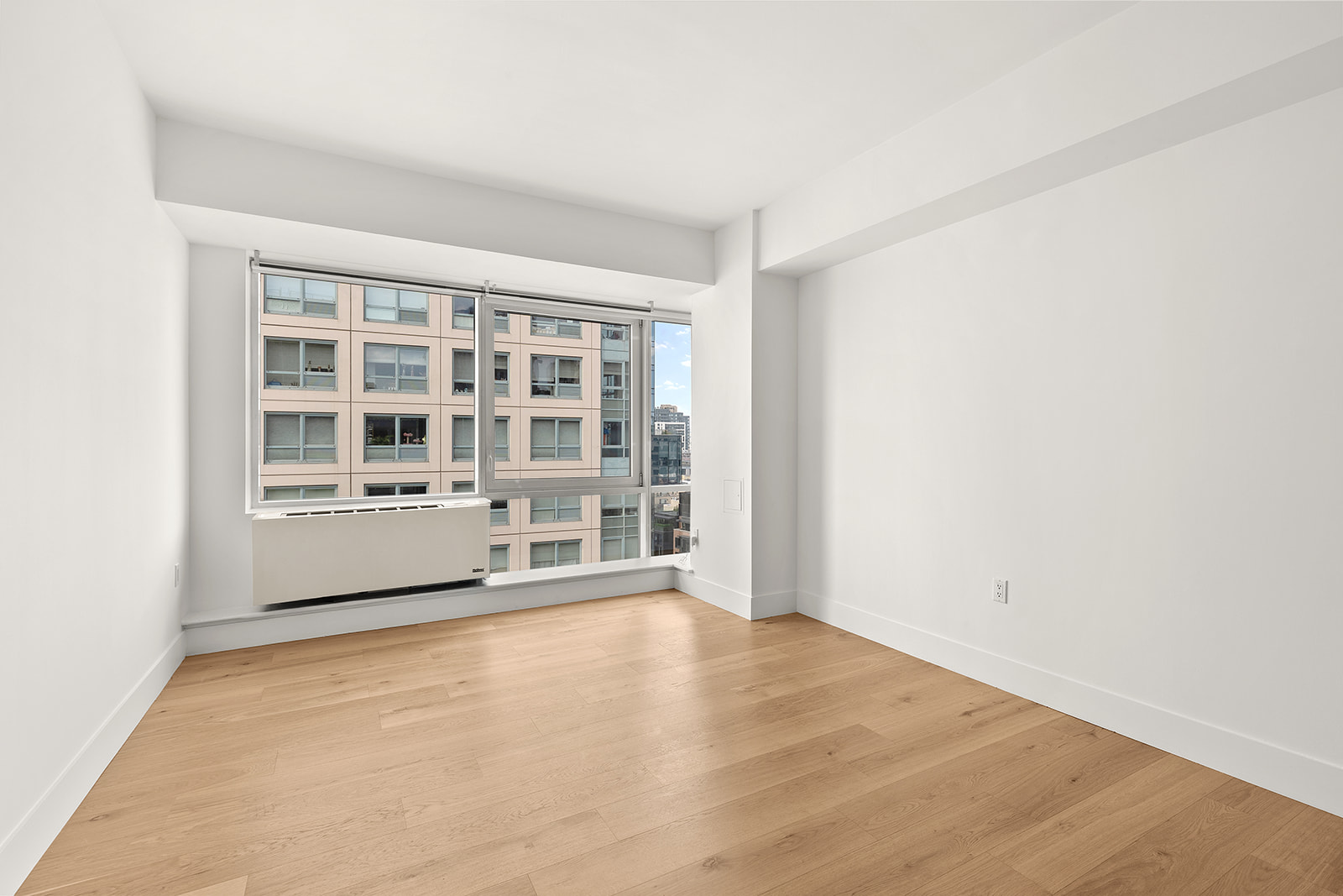 446 Kent Avenue, Unit PHC Brooklyn, NY 11249 - Photo 8 of 22 an empty room with wooden floor and windows