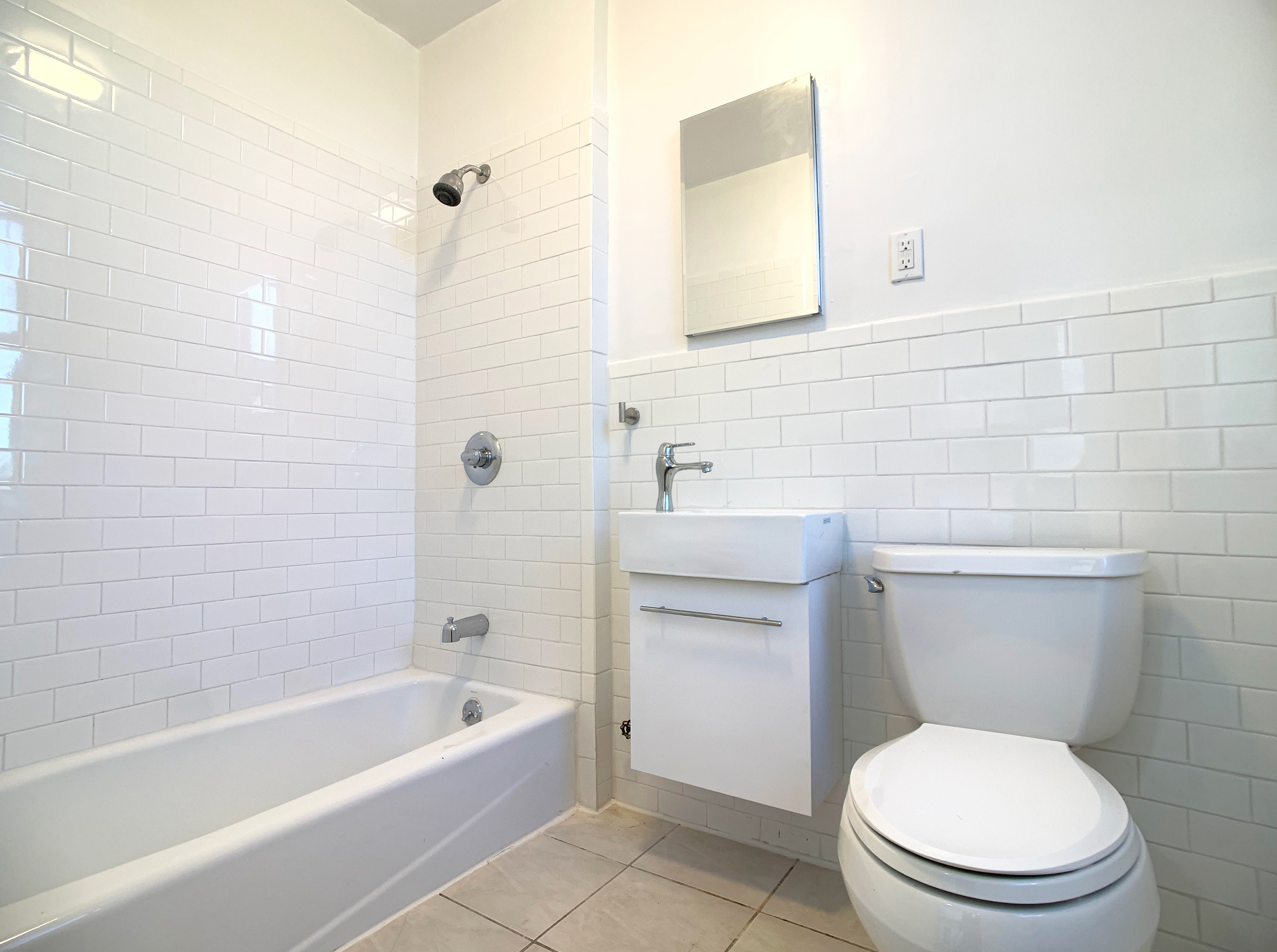 293 Tompkins Avenue Brooklyn, NY 11221 - Photo 18 of 19 a bathroom with a toilet a sink a mirror and bathtub
