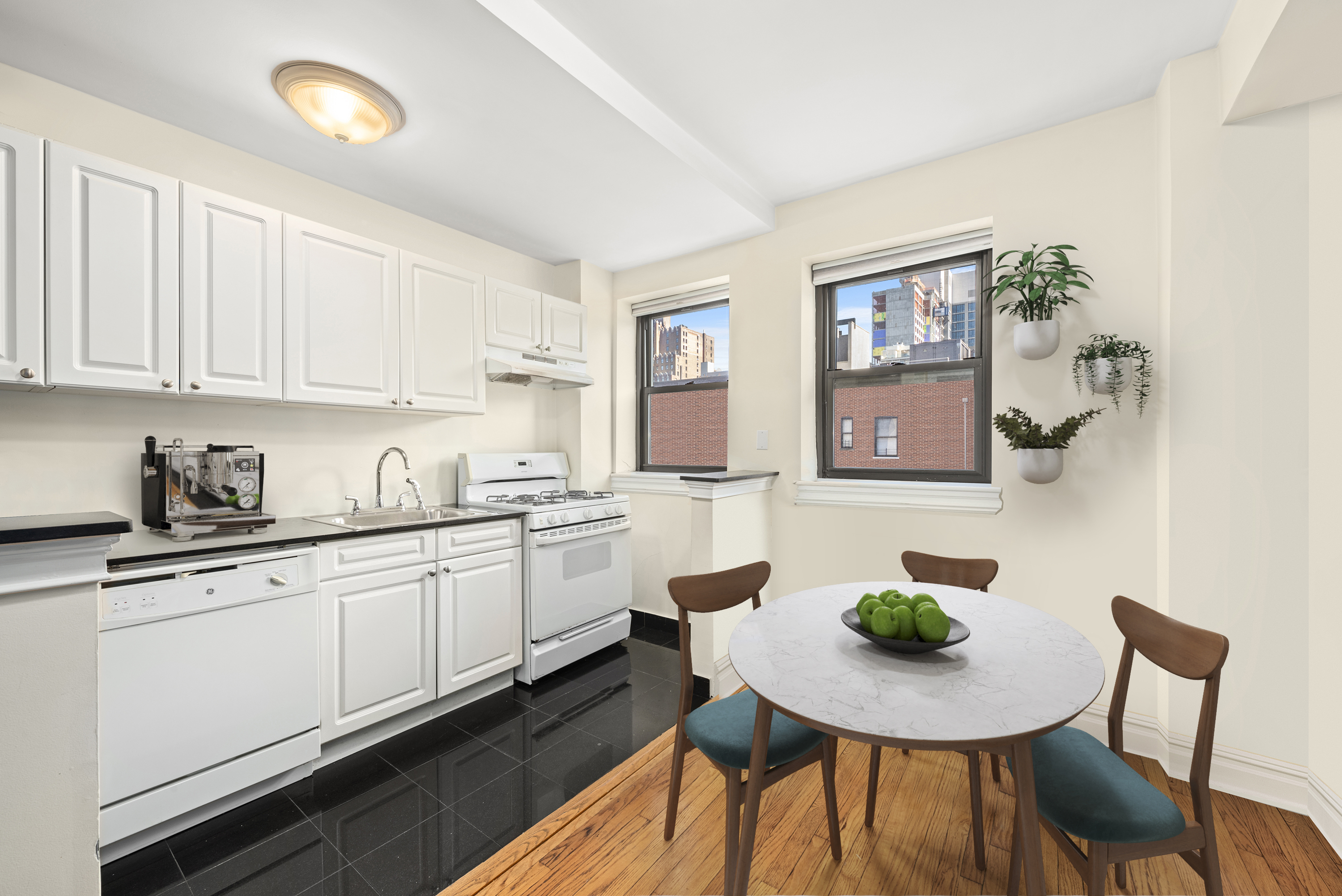 230 Riverside Drive, Unit 8L Manhattan, NY 10025 - Photo 4 of 11 a kitchen with stainless steel appliances kitchen island granite countertop a sink cabinets and window