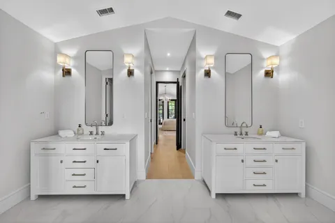 walk in bathroom with a double vanity sink and mirror