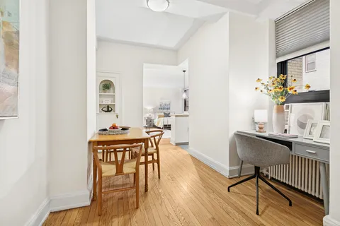 a living room with furniture a wooden floor and next to a window