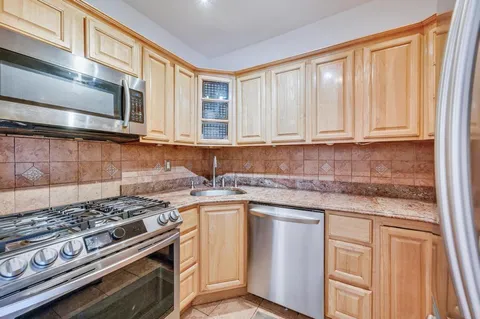 a kitchen with stainless steel appliances granite countertop a stove and a microwave