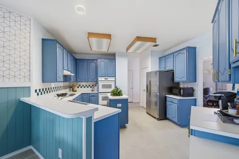 a kitchen with a refrigerator a stove a sink dishwasher and wooden cabinets with wooden floor