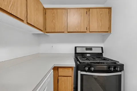 a kitchen with white cabinets and a stove top oven
