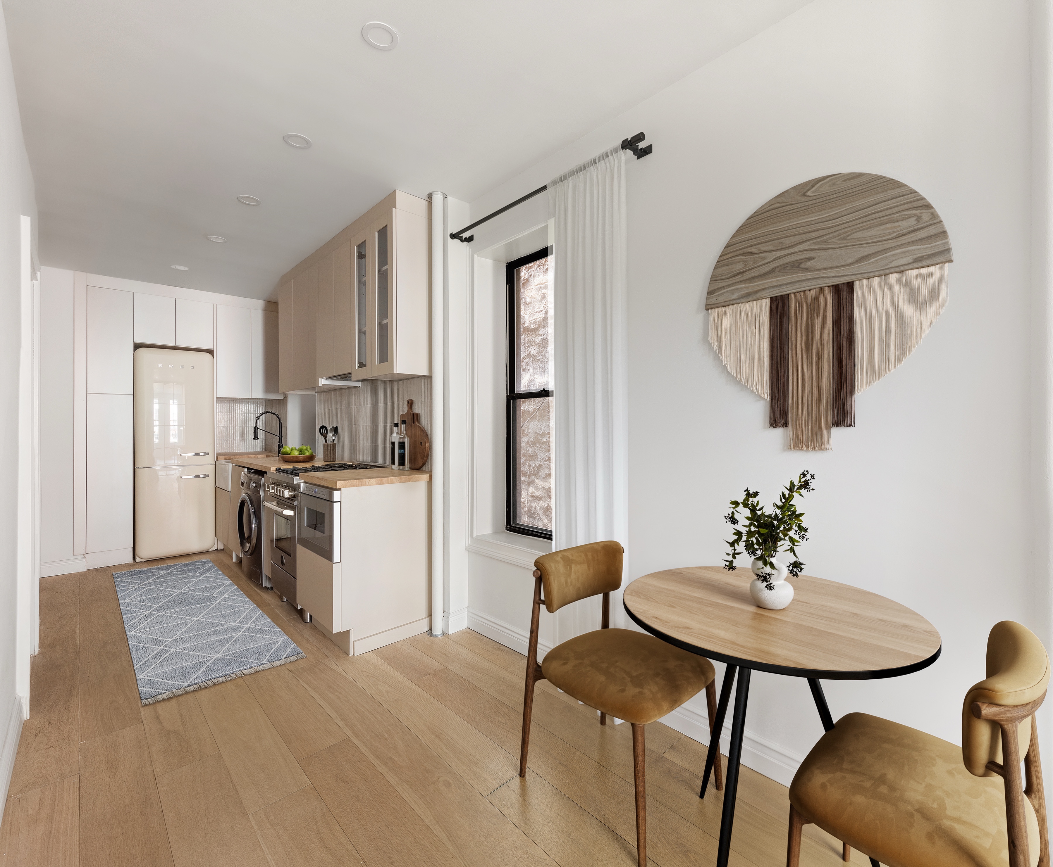 228 West 16th Street, Unit 4B Manhattan, NY 10011 - Photo 2 of 9 a kitchen with stainless steel appliances granite countertop a table chairs and a refrigerator