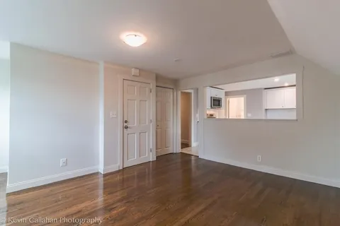 a view of a livingroom with wooden floor and windows