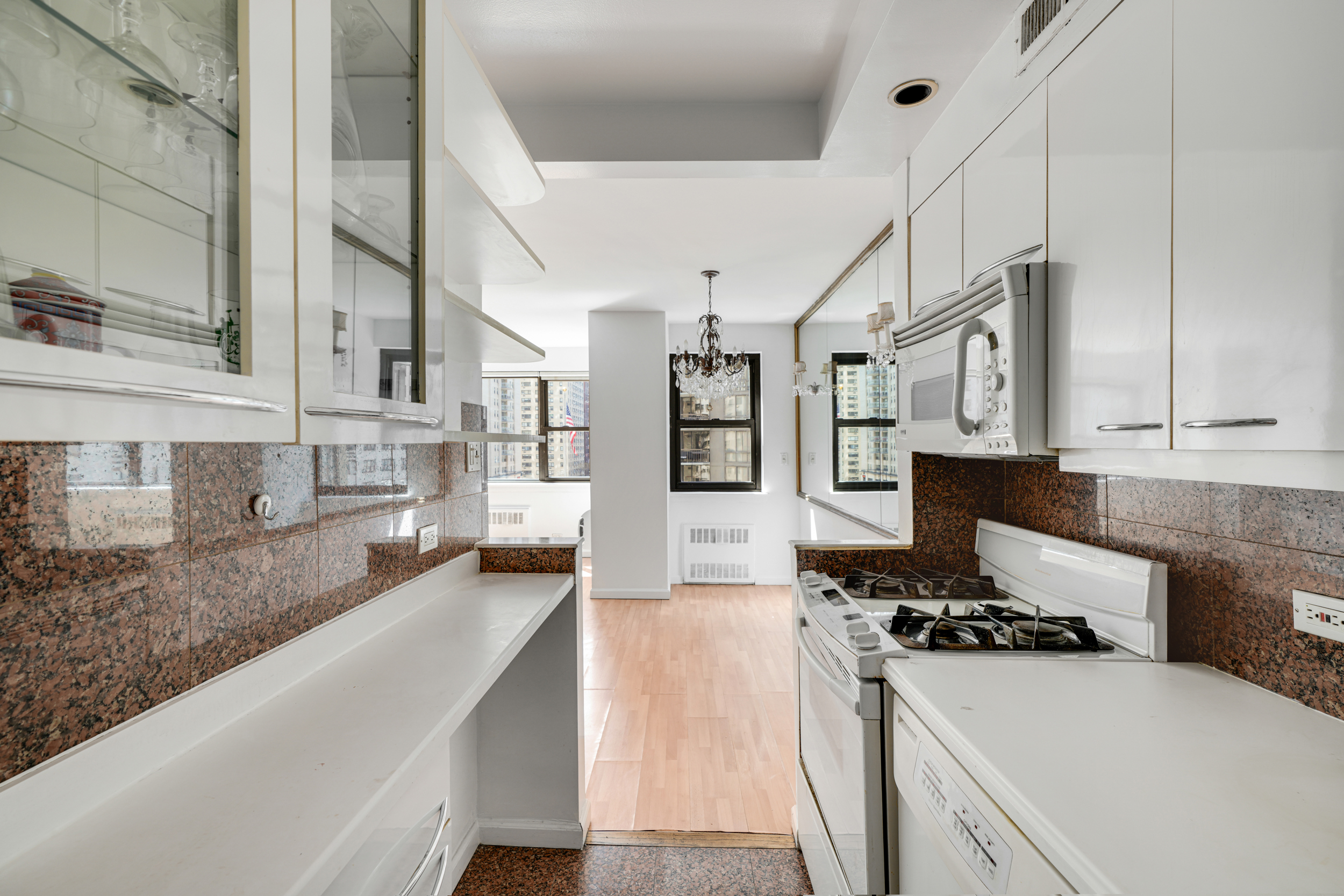 357 East 57th Street, Unit 5D Manhattan, NY 10022 - Photo 6 of 23 a kitchen with stainless steel appliances granite countertop a stove and a sink