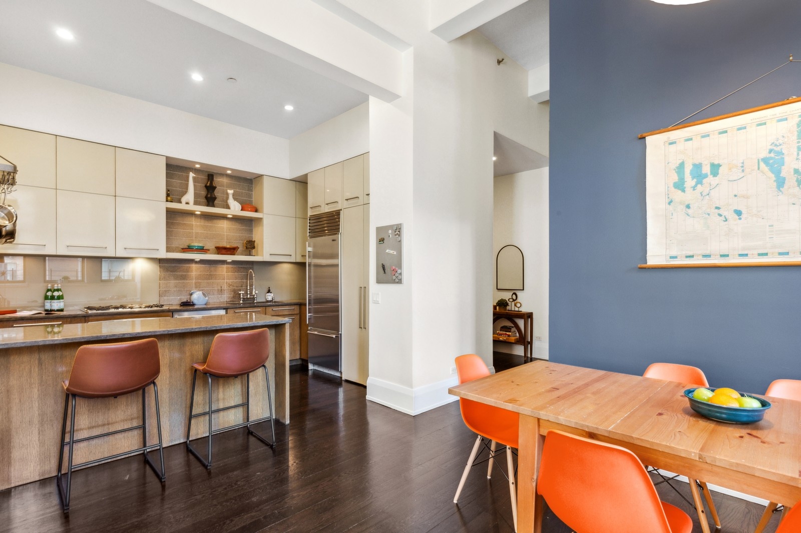 263 9th Avenue, Unit 3D Manhattan, NY 10001 - Photo 2 of 15 a kitchen with stainless steel appliances granite countertop a table chairs and wooden floor