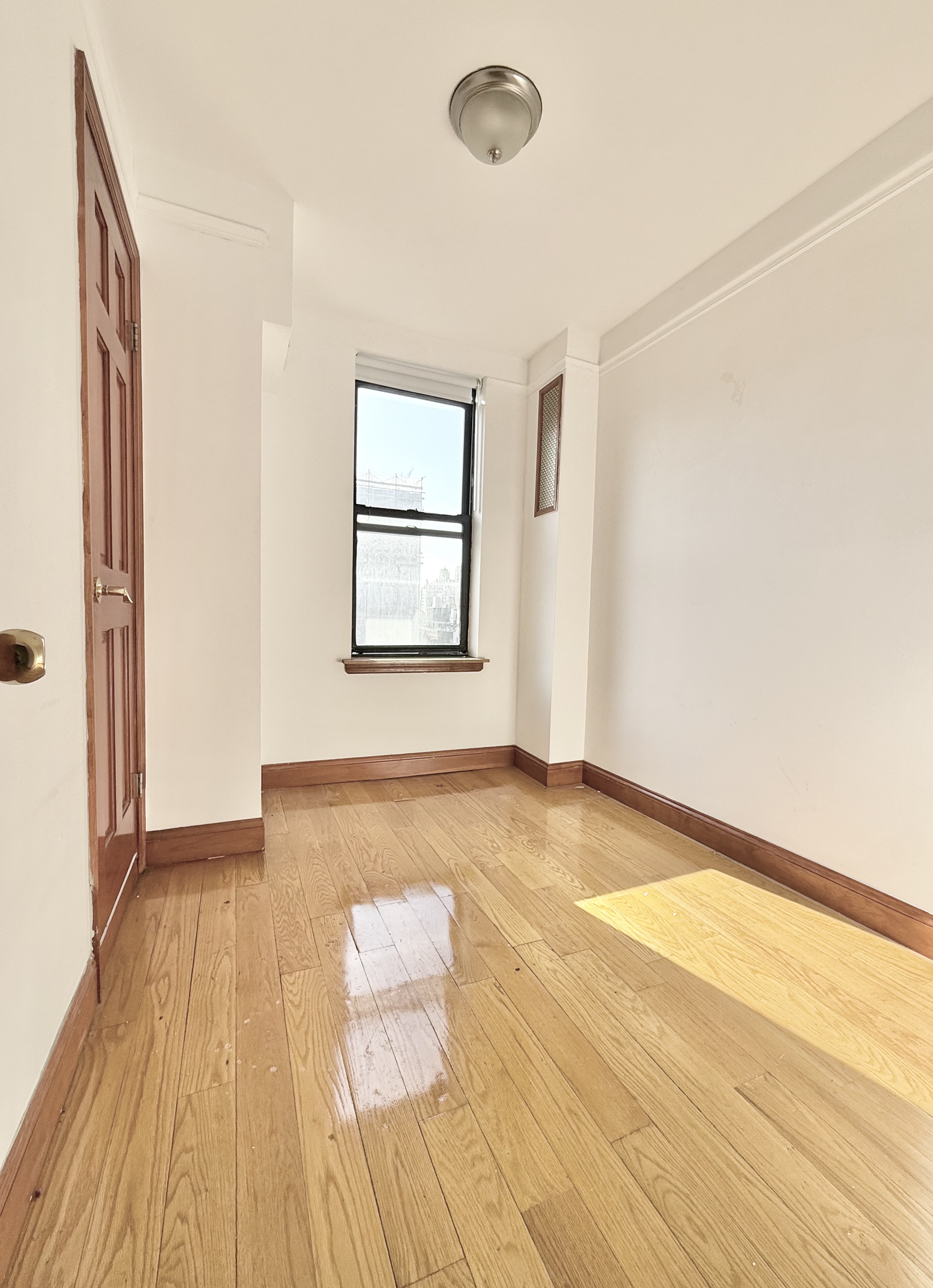 675 West End Avenue, Unit 12A Manhattan, NY 10025 - Photo 10 of 15 a view of an empty room with wooden floor and a window
