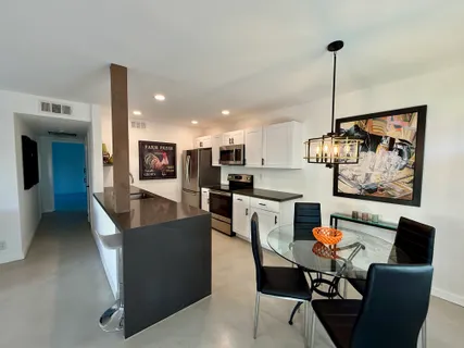 a living room with stainless steel appliances kitchen island granite countertop furniture and a kitchen view