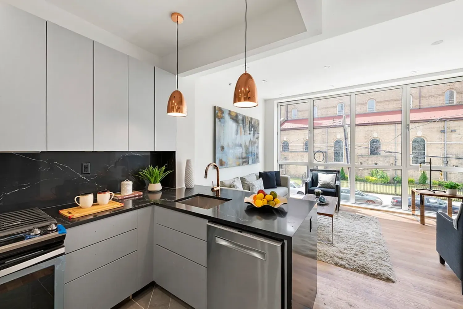 a kitchen with a sink a counter top space and living room view