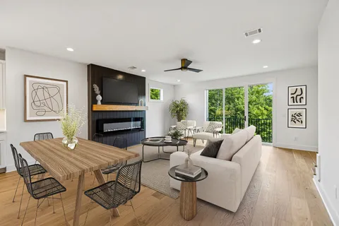 a living room with furniture a flat screen tv and a large window