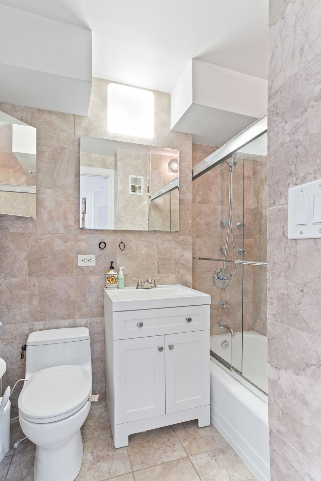 900 West 190th Street, Unit 11J Manhattan, NY 10040 - Photo 5 of 15 a bathroom with a granite countertop toilet a sink and mirror