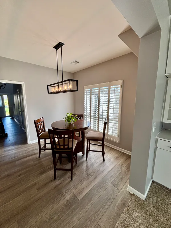 a view of a dining room with furniture and wooden floor