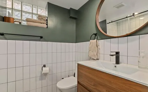 a bathroom with a sink a toilet and a mirror