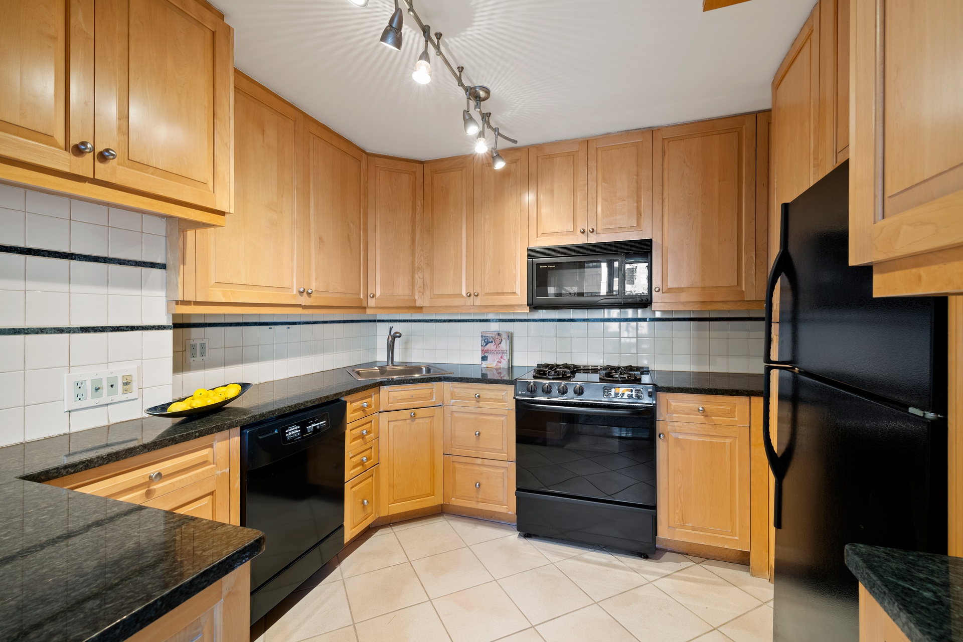 444 East 86th Street, Unit 14G Manhattan, NY 10028 - Photo 6 of 10 a kitchen with granite countertop stainless steel appliances and wooden cabinets
