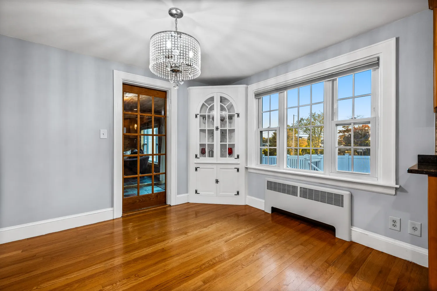 a view of an empty room with a window and wooden floor