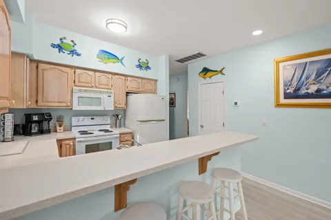 a kitchen with appliances cabinets and wooden floor