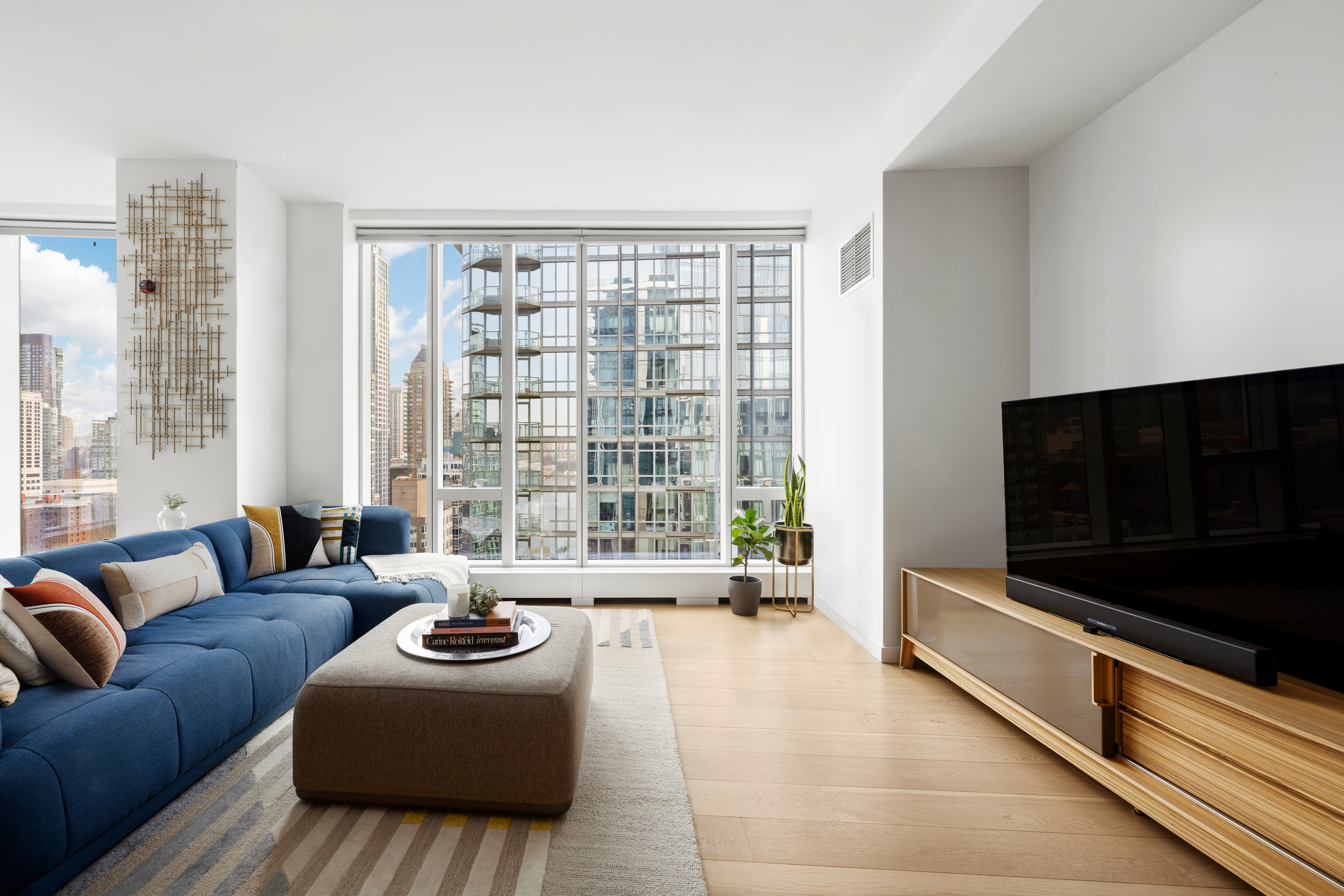 1 West End Avenue, Unit 22C Manhattan, NY 10023 - Photo 5 of 15 a living room with furniture and a flat screen tv