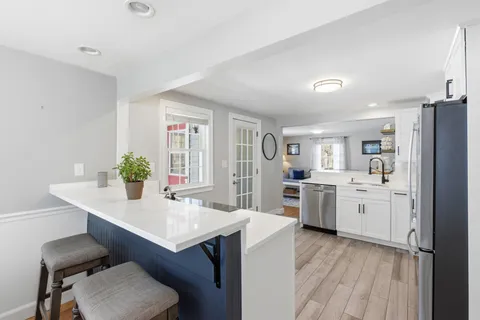 a kitchen with sink refrigerator and dining table