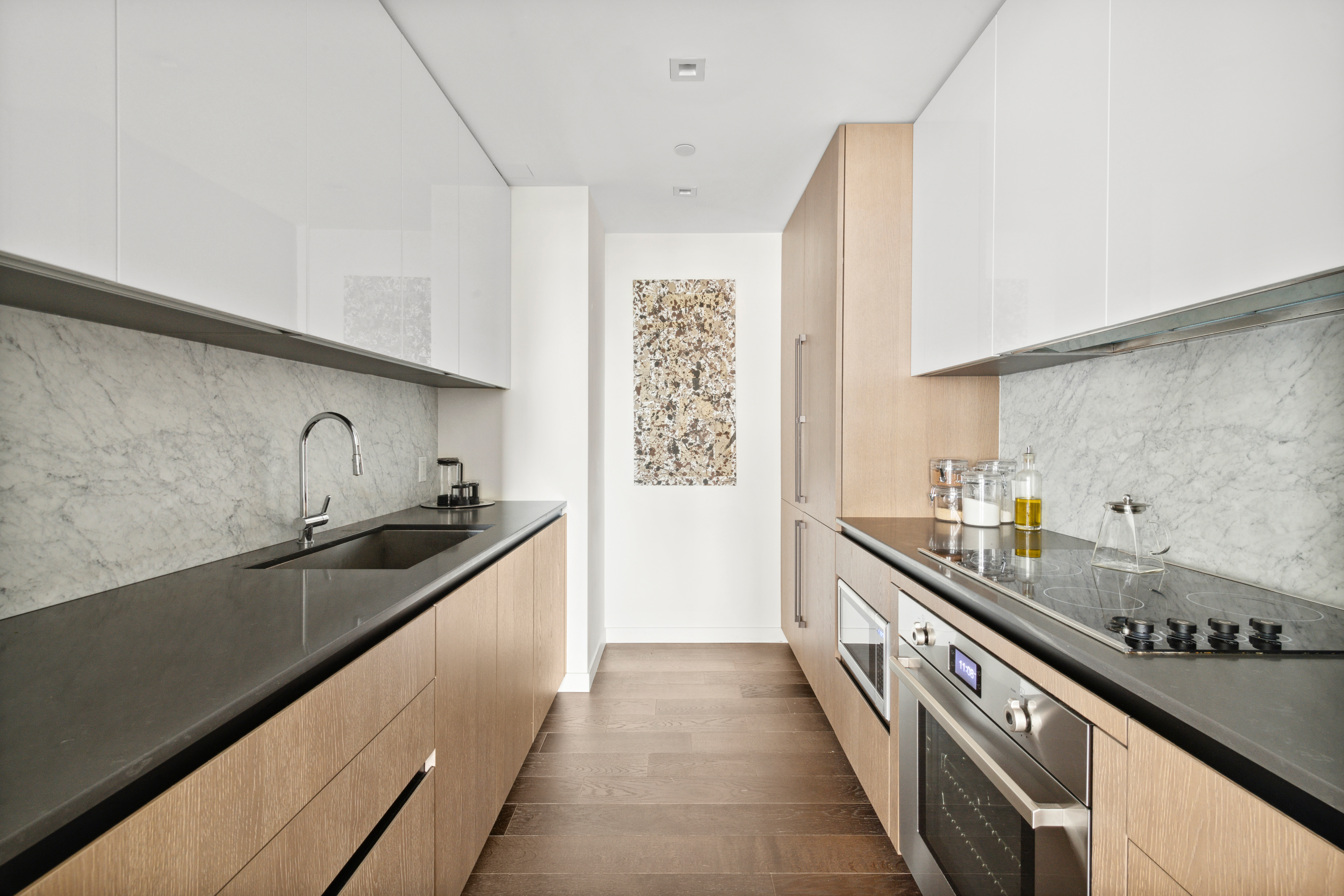 302 East 96th Street, Unit 1302 Manhattan, NY 10128 - Photo 4 of 17 a kitchen with granite countertop a sink stove and cabinets