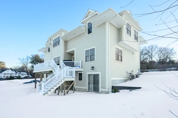 a view of a white house with chairs in front of it