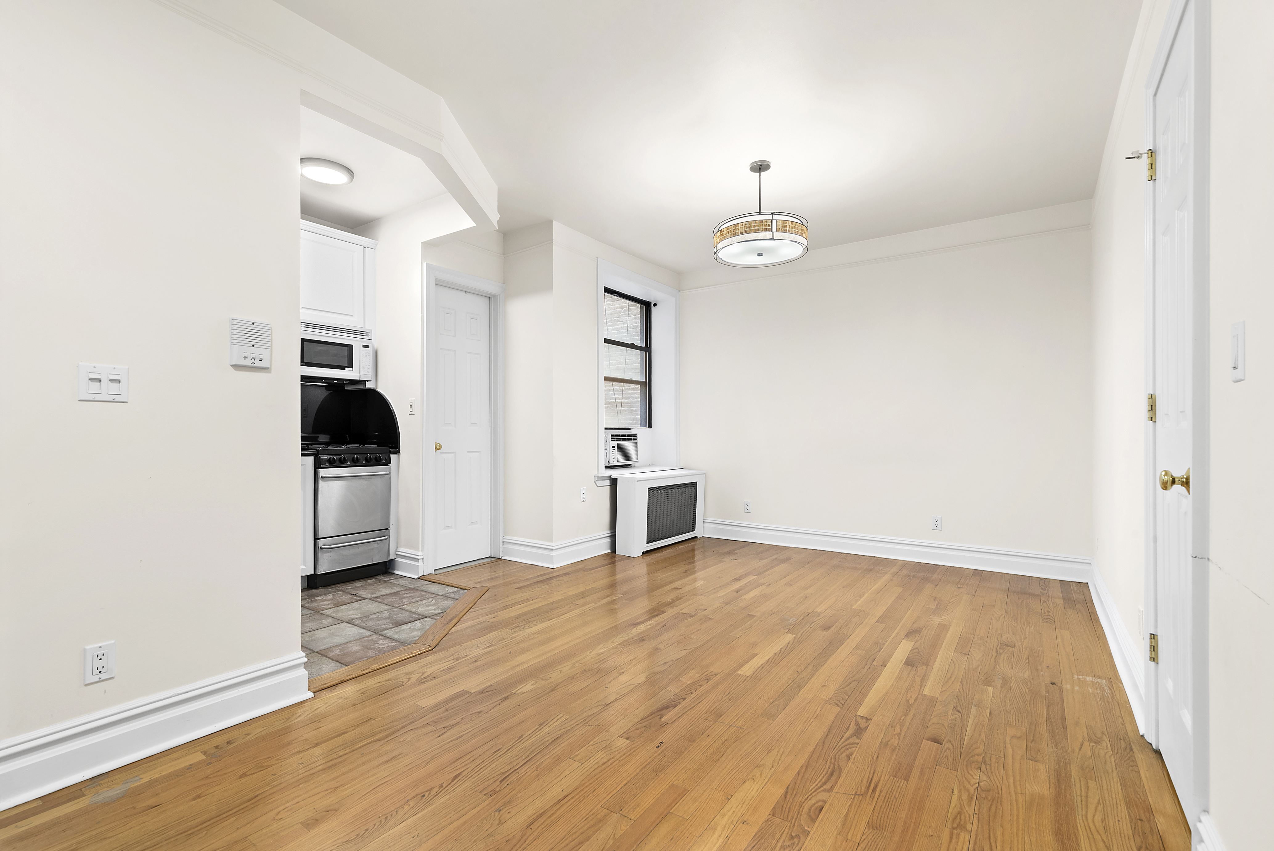680 Riverside Drive, Unit 1E Manhattan, NY 10031 - Photo 3 of 6 wooden floor in an empty room with a window