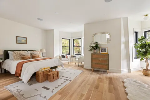 a bedroom with a bed and wooden floor