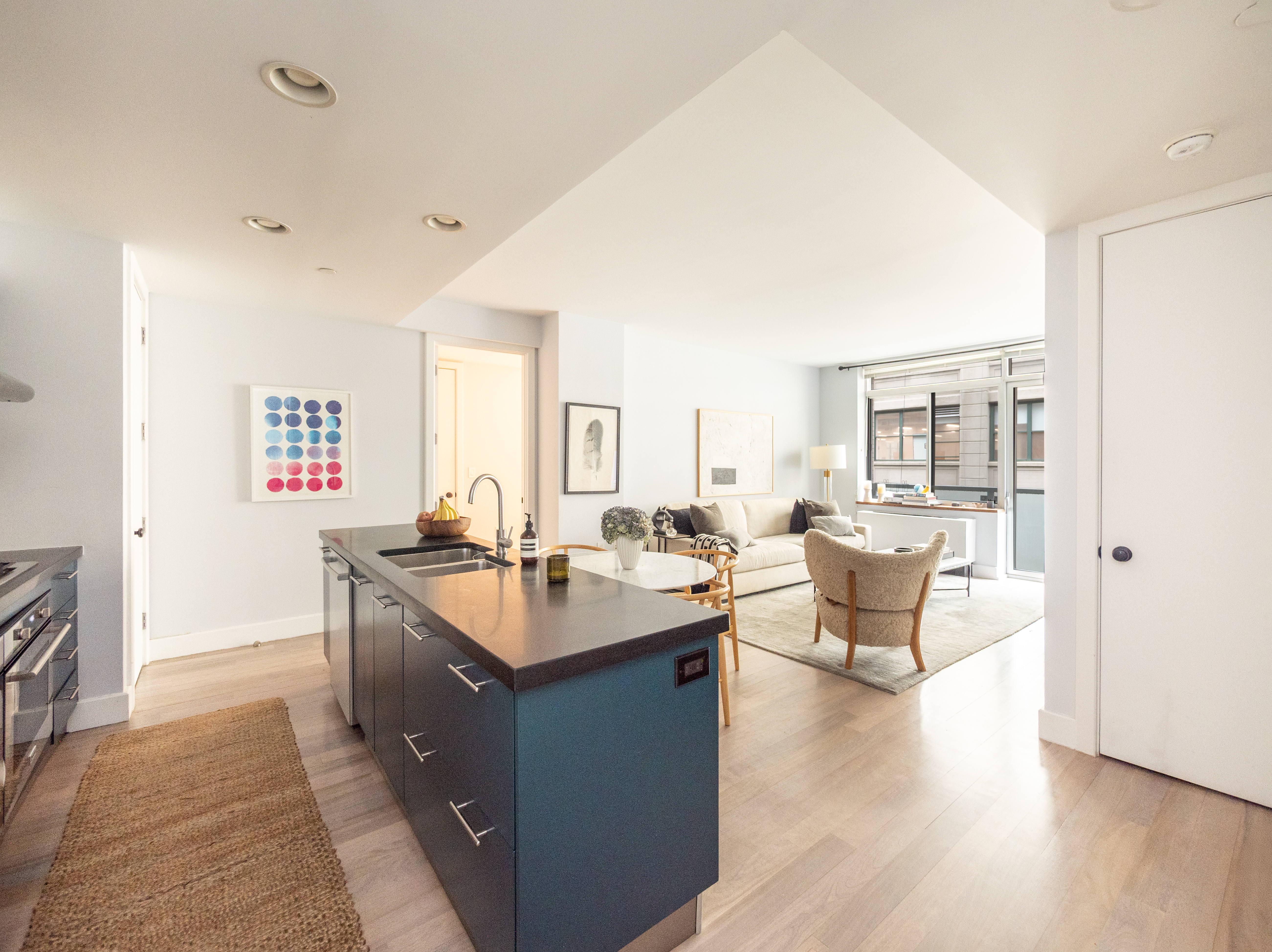 84 Front Street, Unit 5E Brooklyn, NY 11201 - Photo 3 of 11 a large living room with stainless steel appliances granite countertop a sink and dishwasher a stove with wooden floor