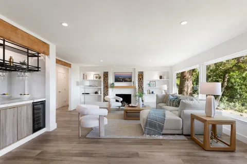 a living room with fireplace furniture and a large window