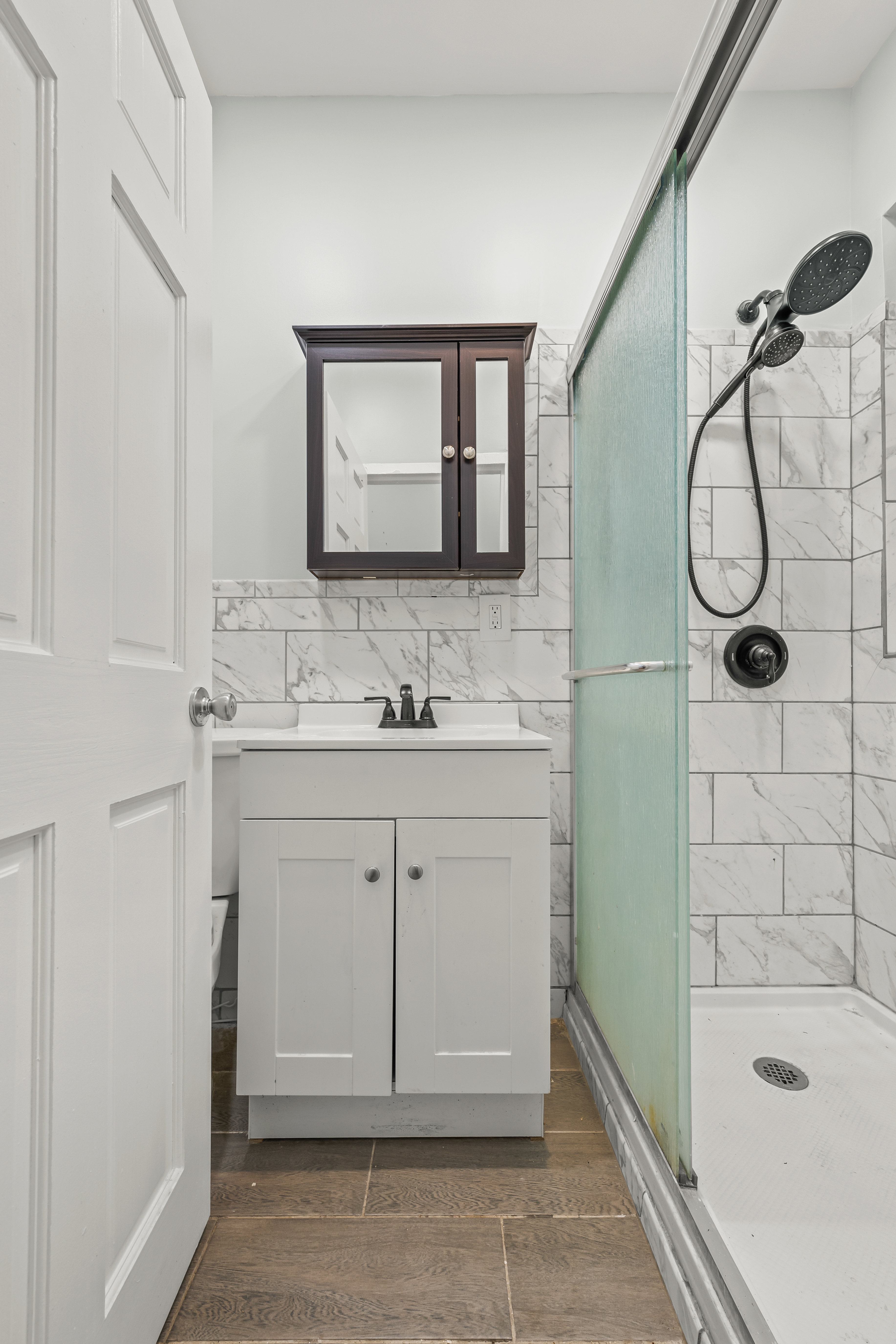 2023 Hughes Avenue Bronx, NY 10457 - Photo 15 of 63 a bathroom with a granite countertop sink a mirror and shower