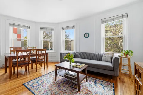 a living room with furniture wooden floor and a table