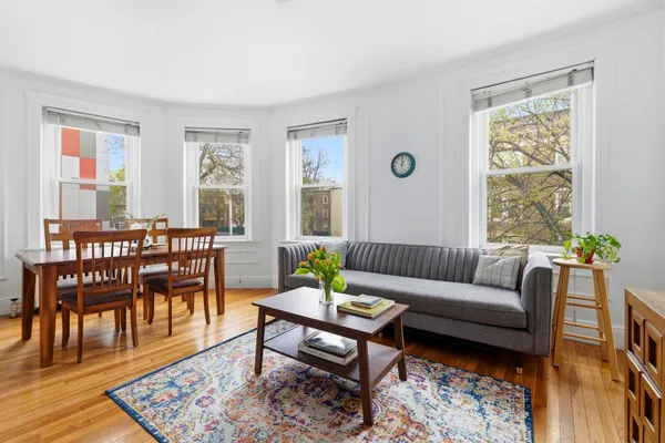 a living room with furniture wooden floor and a table