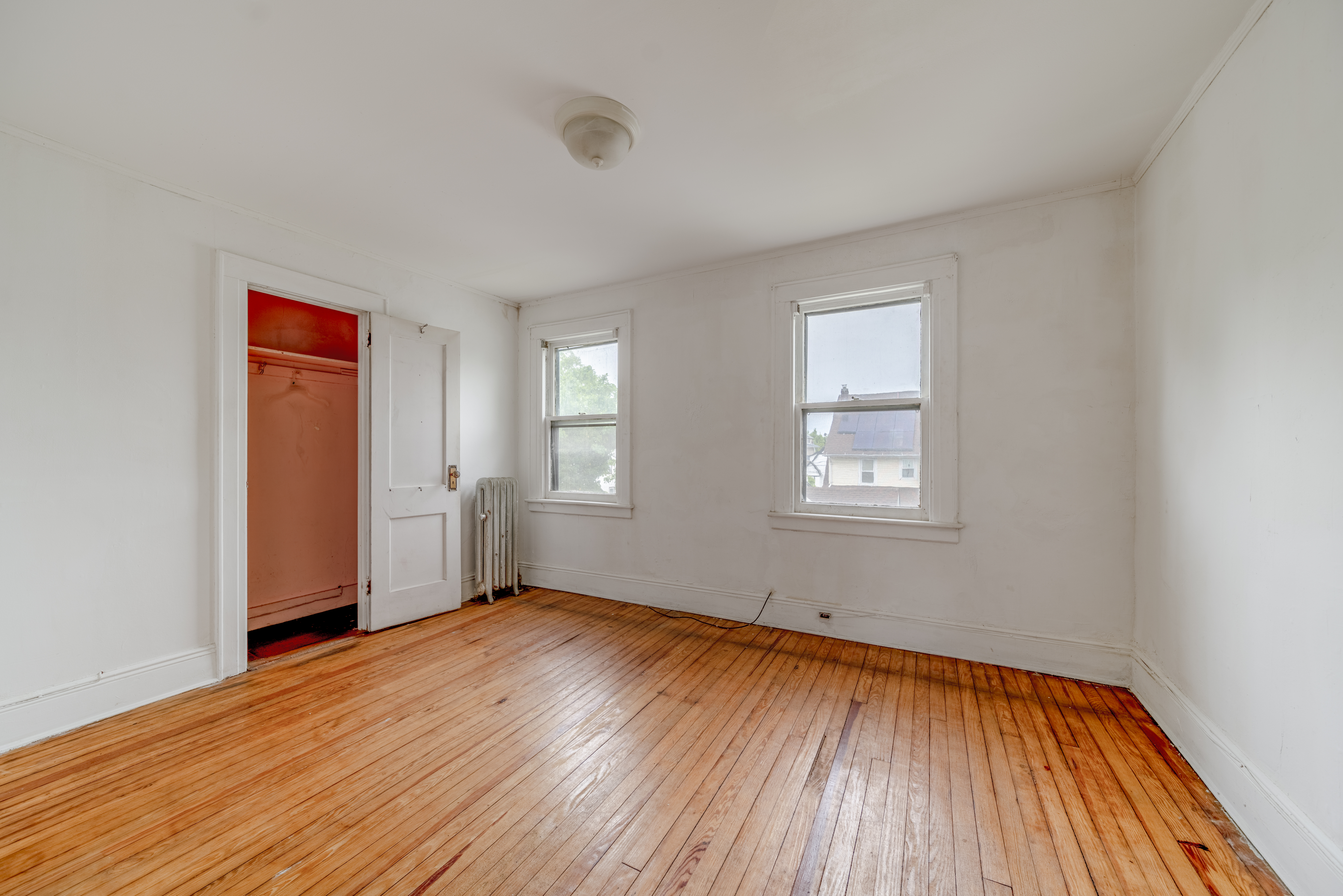 100-30 198th Street Queens, NY 11423 - Photo 9 of 15 an empty room with wooden floor and windows