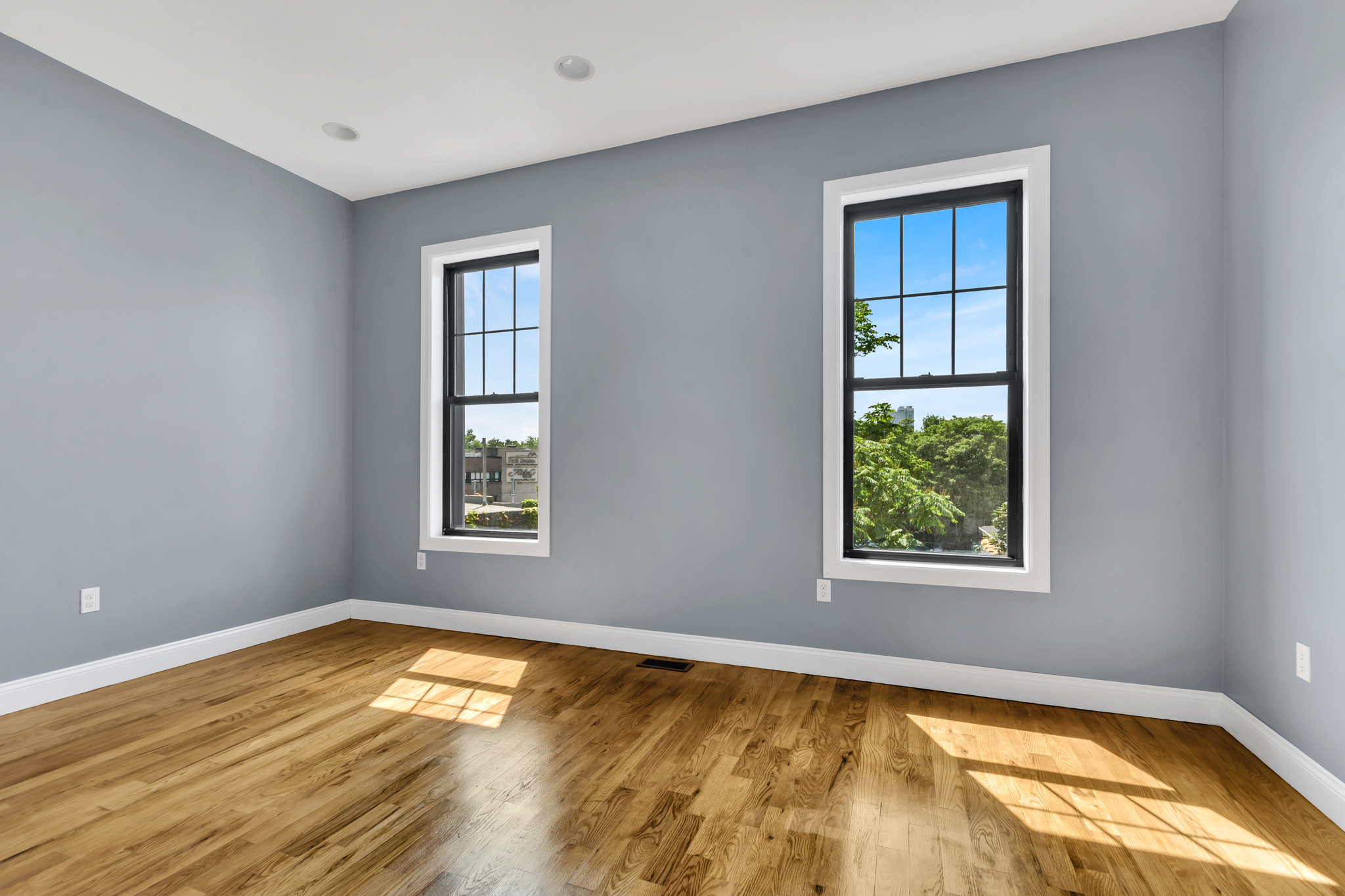28 Roosevelt Place, Unit 2 Brooklyn, NY 11233 - Photo 7 of 12 a view of an empty room with a window and wooden floor