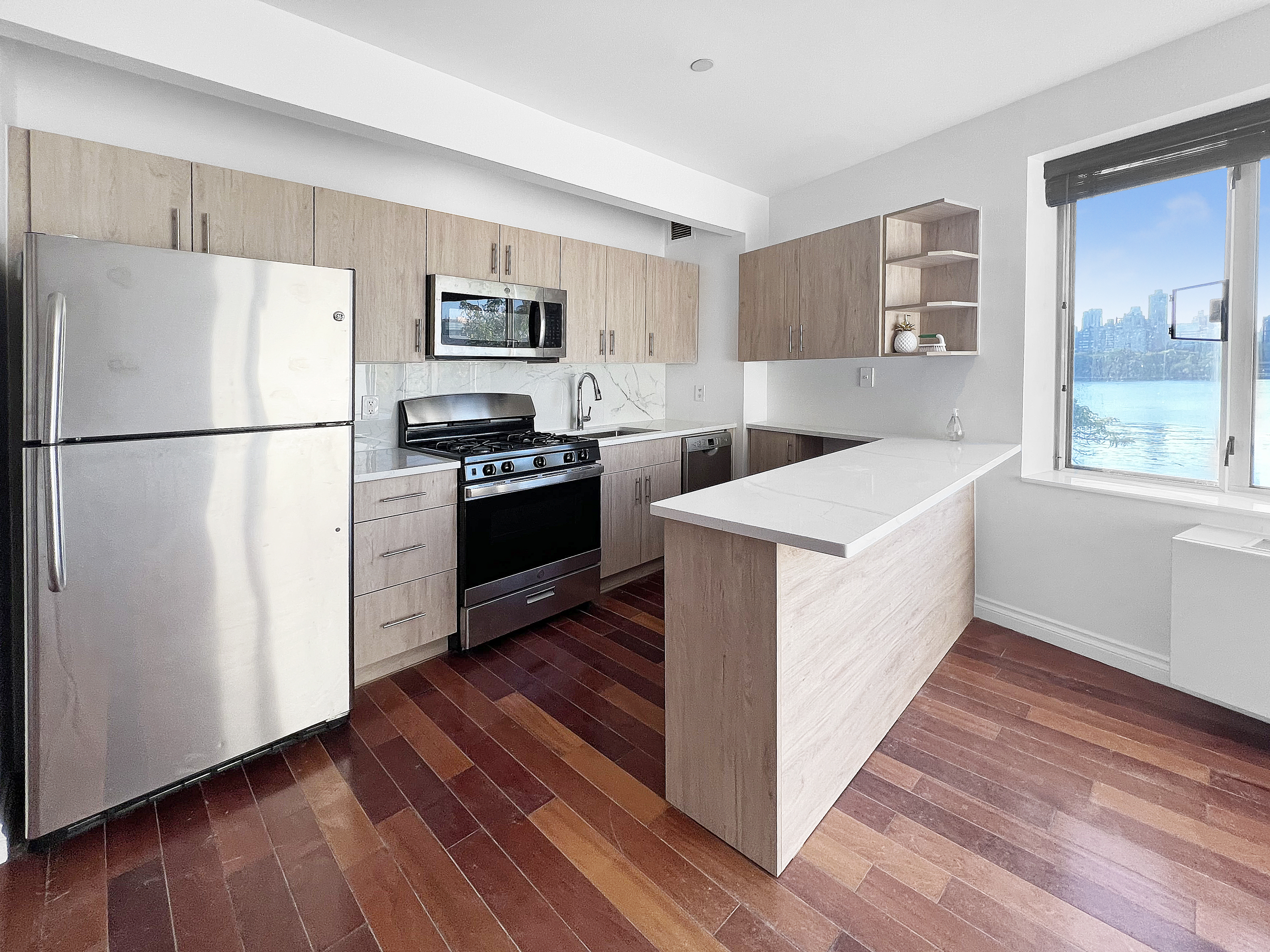 30-85 Vernon Boulevard, Unit 3M Queens, NY 11102 - Photo 3 of 8 a kitchen with stainless steel appliances a refrigerator sink and microwave