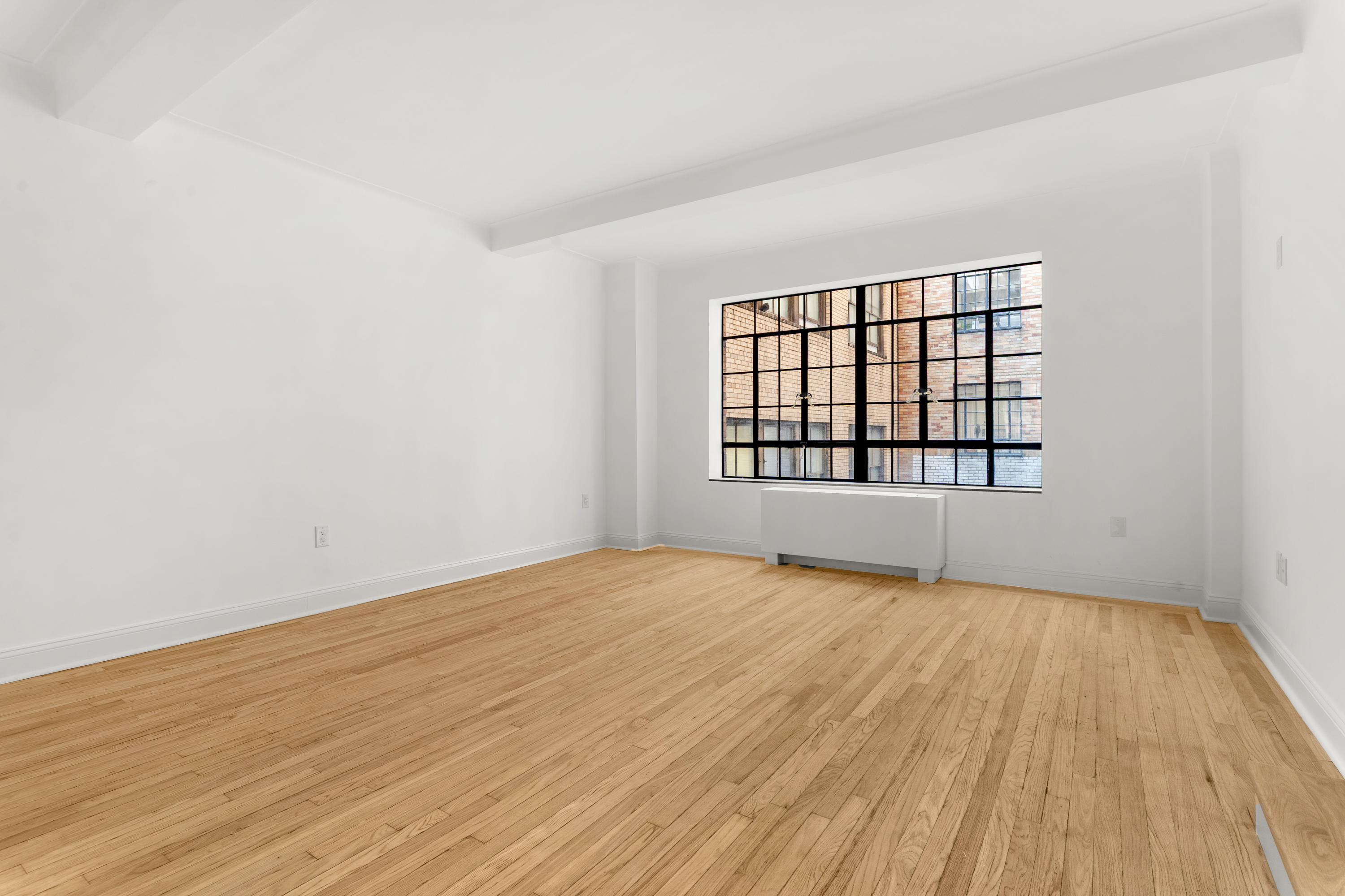 10 Park Avenue, Unit 6A Manhattan, NY 10016 - Photo 4 of 14 wooden floor in an empty room with a window