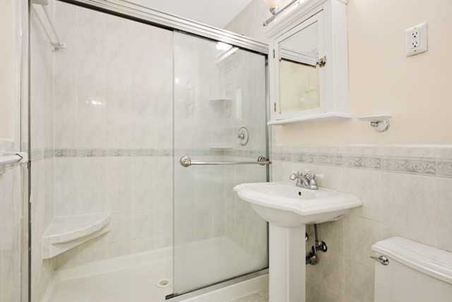165 Christopher Street, Unit 5CC Manhattan, NY 10014 - Photo 6 of 13 a bathroom with a sink shower and a mirror