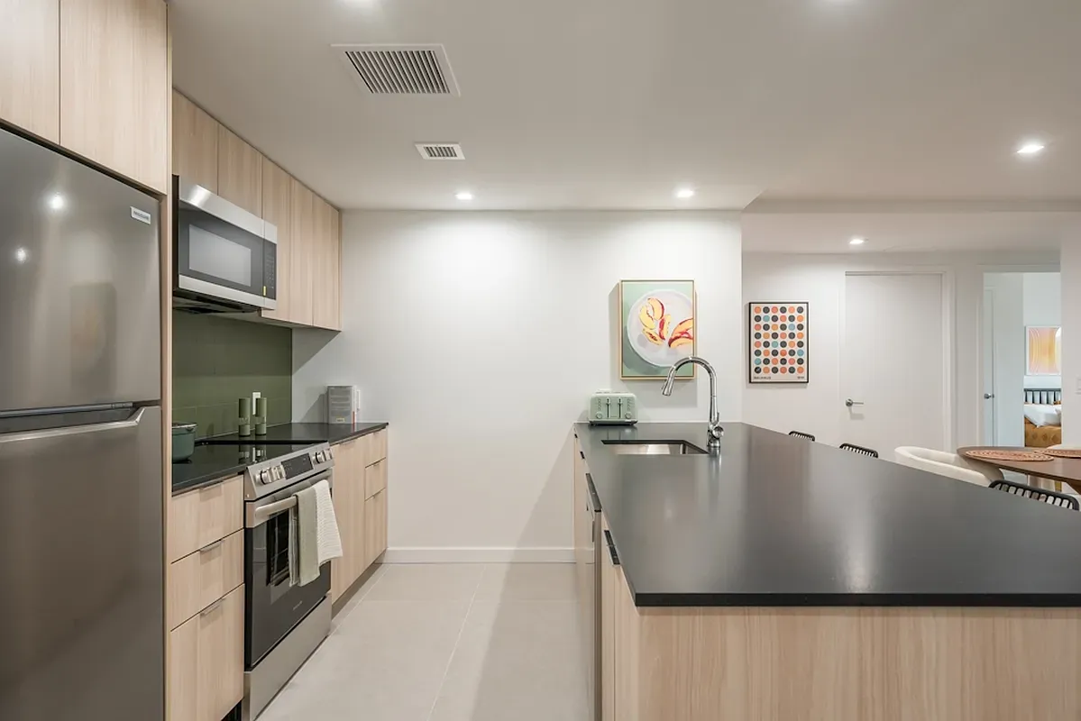 a kitchen with stainless steel appliances granite countertop a sink a stove and a refrigerator