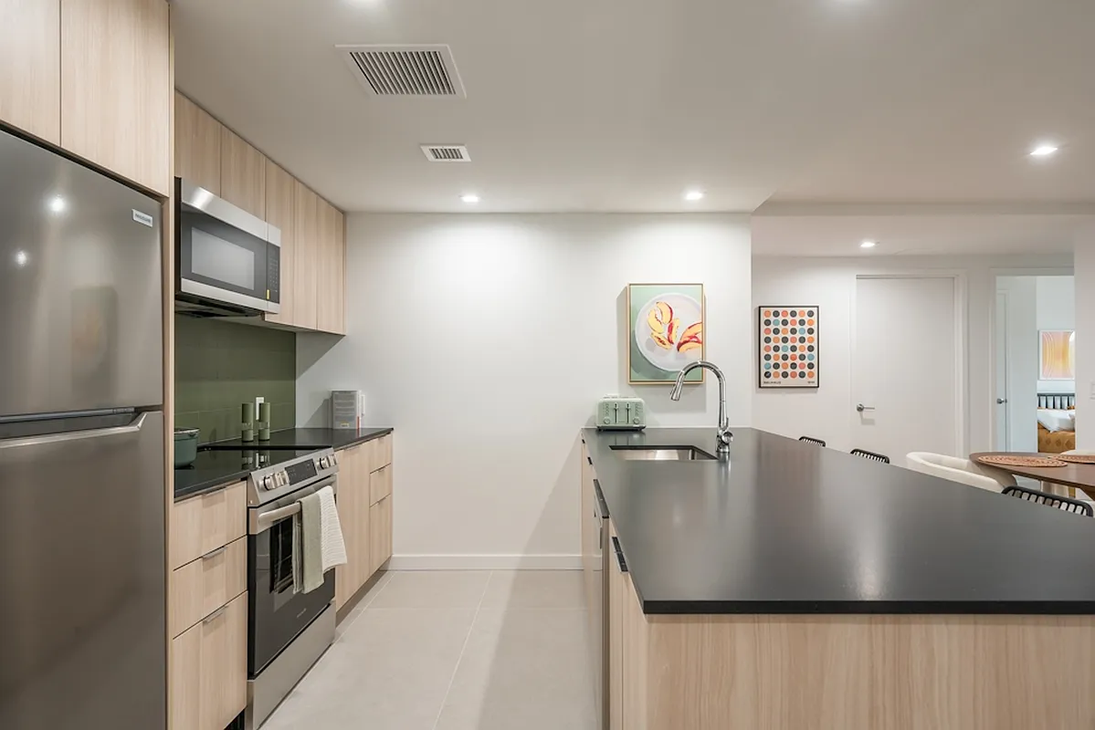 a kitchen with stainless steel appliances granite countertop a sink a stove and a refrigerator