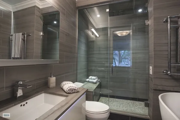 a bathroom with a granite countertop toilet a sink a mirror and shower